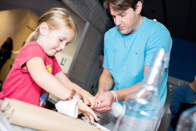 Young girl and adult man working on an engineering project together